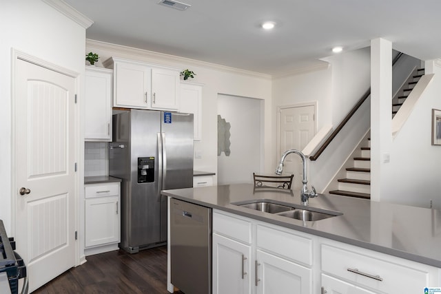 kitchen featuring a sink, white cabinetry, stainless steel appliances, crown molding, and dark wood-style flooring