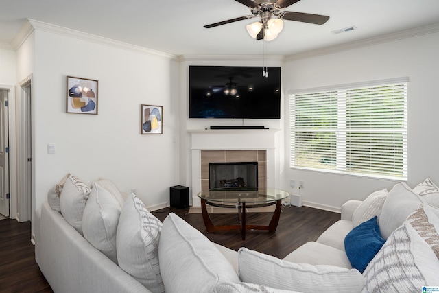 living area with visible vents, wood finished floors, a tile fireplace, and ornamental molding