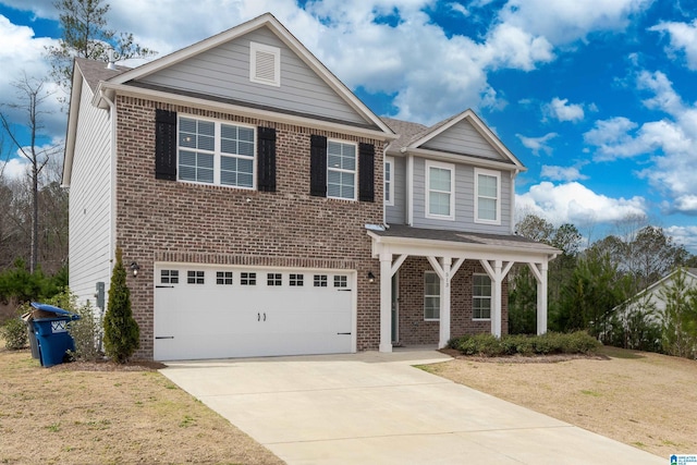 traditional home with covered porch, concrete driveway, an attached garage, a front yard, and brick siding