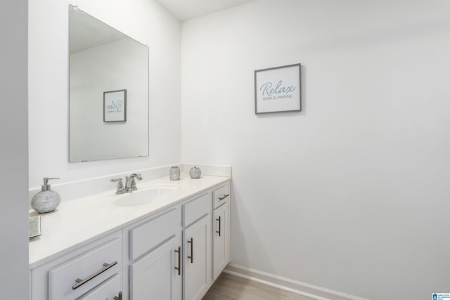 bathroom with vanity, baseboards, and wood finished floors