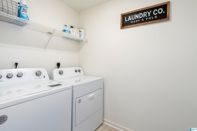 washroom with laundry area, baseboards, and separate washer and dryer