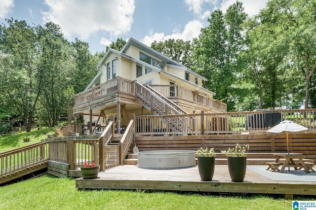 back of property featuring a deck, a yard, and stairway