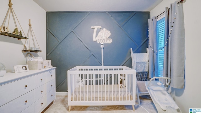 bedroom with a nursery area and light carpet