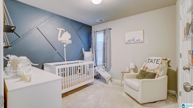 bedroom featuring a nursery area, light carpet, visible vents, and baseboards