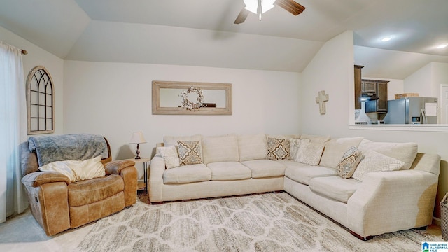 living area featuring lofted ceiling and a ceiling fan