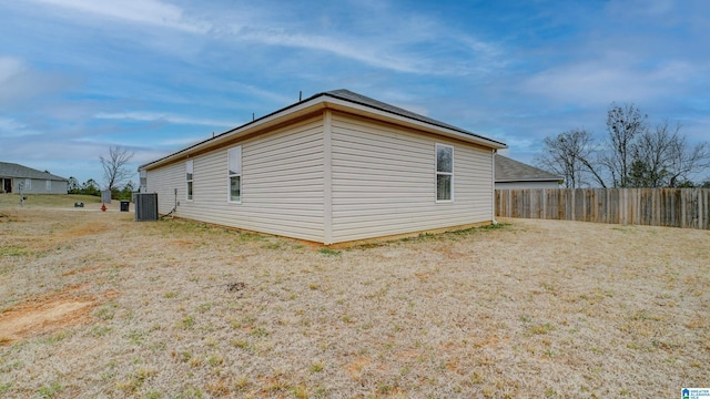 view of side of home featuring cooling unit and fence