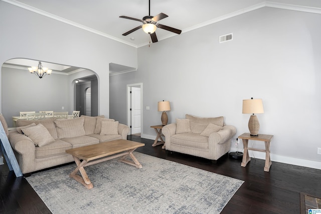 living area featuring wood finished floors, arched walkways, visible vents, and ornamental molding