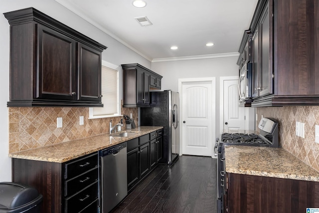 kitchen with dark brown cabinetry, visible vents, stainless steel appliances, and a sink