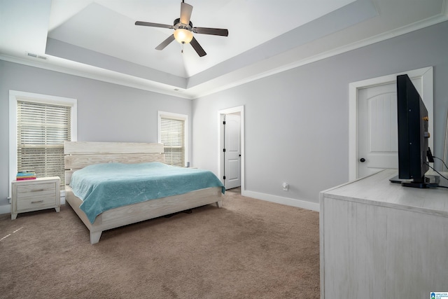 bedroom with a tray ceiling, light colored carpet, and baseboards