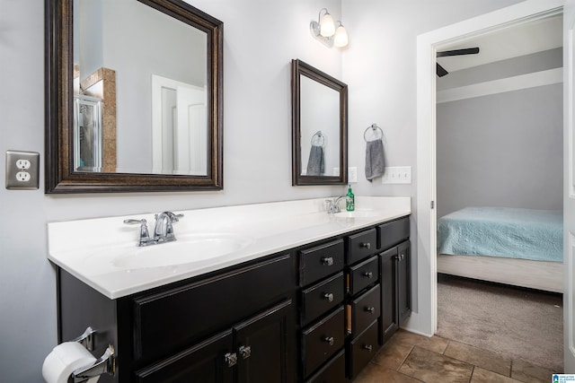 bathroom featuring double vanity, connected bathroom, and a sink