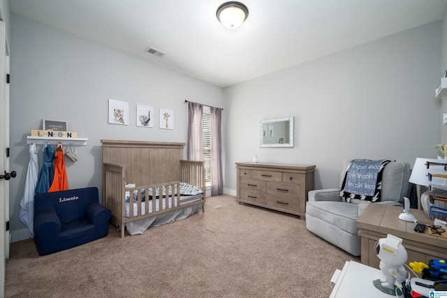 carpeted bedroom with visible vents and a nursery area