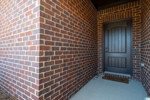 view of exterior entry with brick siding