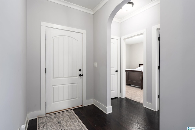 entrance foyer featuring dark wood-type flooring, baseboards, arched walkways, and ornamental molding