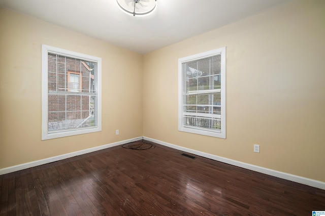 spare room featuring visible vents, baseboards, and hardwood / wood-style floors