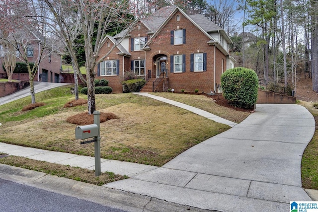 view of front of house with a garage, concrete driveway, brick siding, and a front lawn