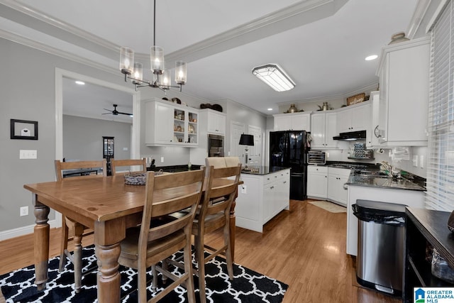 dining space with light wood-style floors, a toaster, and crown molding