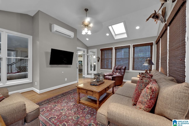 living room featuring recessed lighting, wood finished floors, vaulted ceiling with skylight, a wall mounted air conditioner, and baseboards