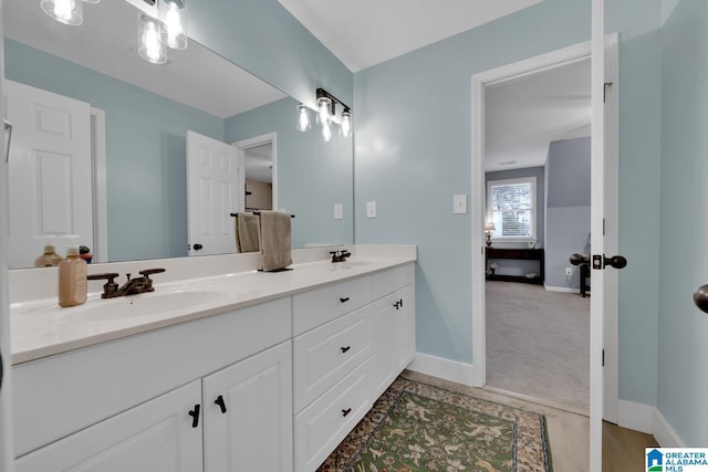 bathroom with a sink, baseboards, and double vanity