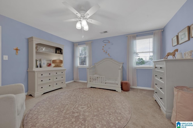 bedroom with light carpet, baseboards, visible vents, and a ceiling fan