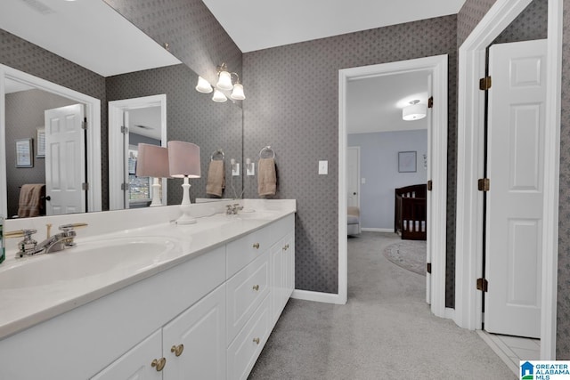 bathroom featuring double vanity, a sink, ensuite bathroom, and wallpapered walls