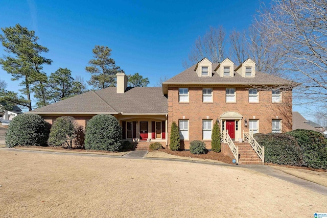 view of front of property with brick siding and a shingled roof