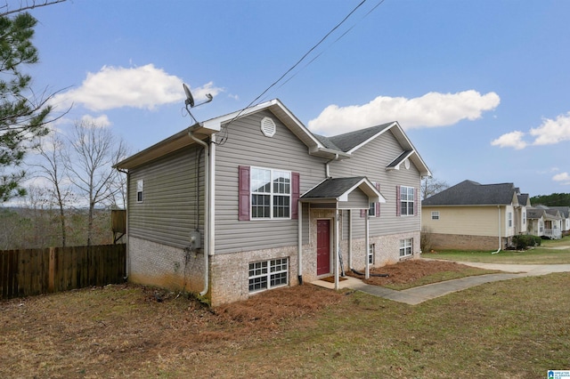 view of front facade featuring a front yard and fence