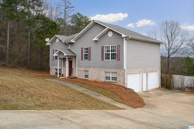 view of front of house featuring concrete driveway, a front lawn, an attached garage, and fence