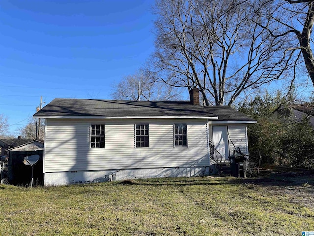 view of side of home featuring entry steps, crawl space, a yard, and a chimney