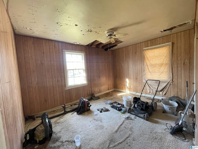 workout room featuring a ceiling fan and wooden walls