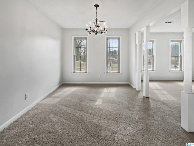 carpeted empty room with visible vents, decorative columns, and baseboards