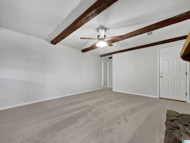 interior space featuring baseboards, light colored carpet, ceiling fan, beamed ceiling, and a textured ceiling