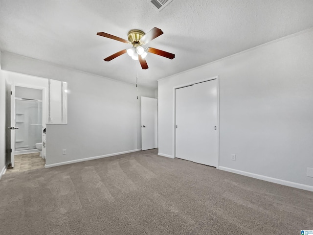 unfurnished bedroom with visible vents, a textured ceiling, baseboards, and carpet flooring