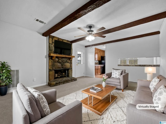 living room with light carpet, baseboards, visible vents, beamed ceiling, and a stone fireplace