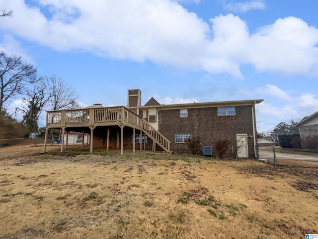 back of house featuring a deck, cooling unit, brick siding, fence, and stairs