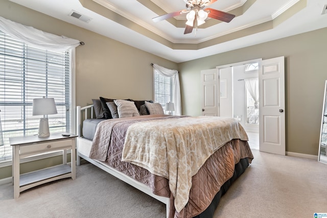 bedroom featuring light carpet, baseboards, visible vents, a raised ceiling, and ornamental molding