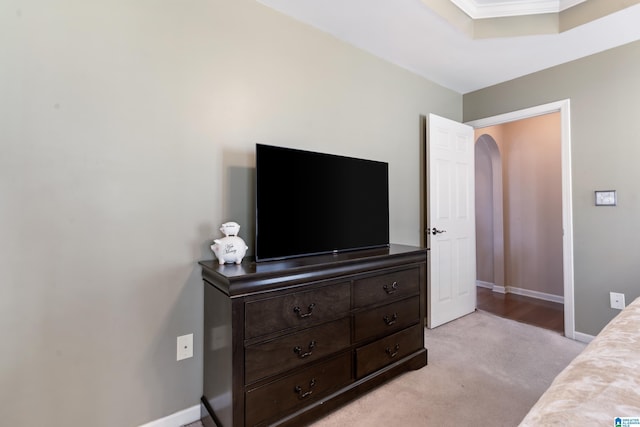 bedroom with arched walkways, light colored carpet, and baseboards