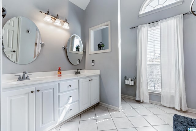 full bath with double vanity, a sink, baseboards, and tile patterned floors