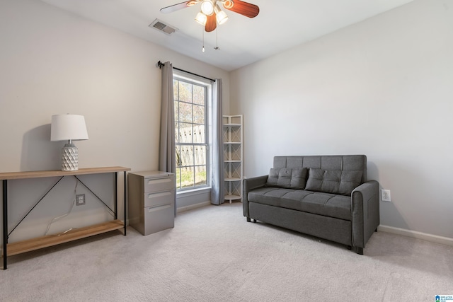 living area with carpet floors, visible vents, baseboards, and a ceiling fan