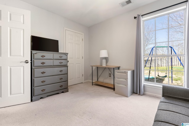 living area with light colored carpet, visible vents, and baseboards