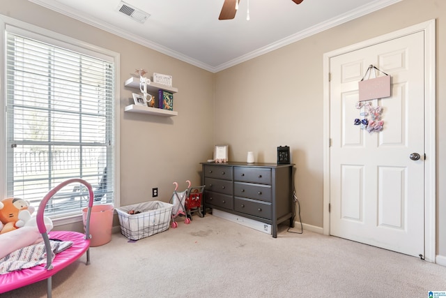 interior space with baseboards, visible vents, a ceiling fan, ornamental molding, and carpet