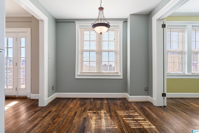 unfurnished dining area with dark wood-style floors and baseboards