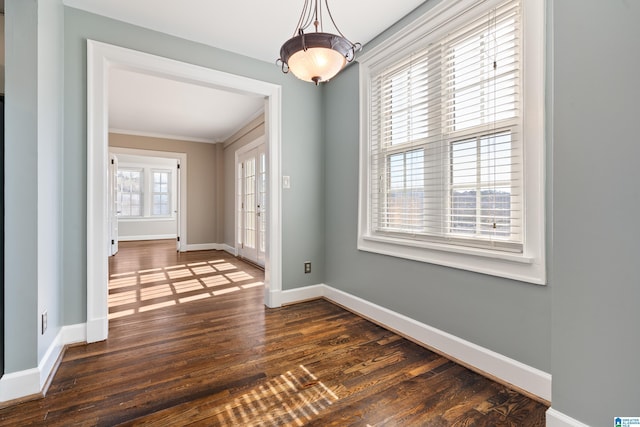 unfurnished dining area with baseboards and dark wood-type flooring