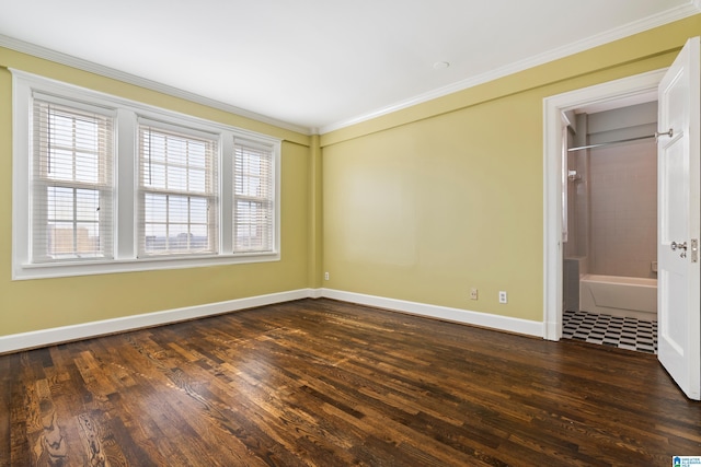 spare room featuring baseboards, dark wood-type flooring, and crown molding