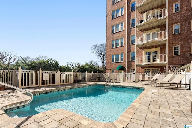 pool with a patio and fence