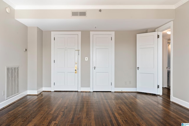 unfurnished room featuring dark wood finished floors, visible vents, and crown molding