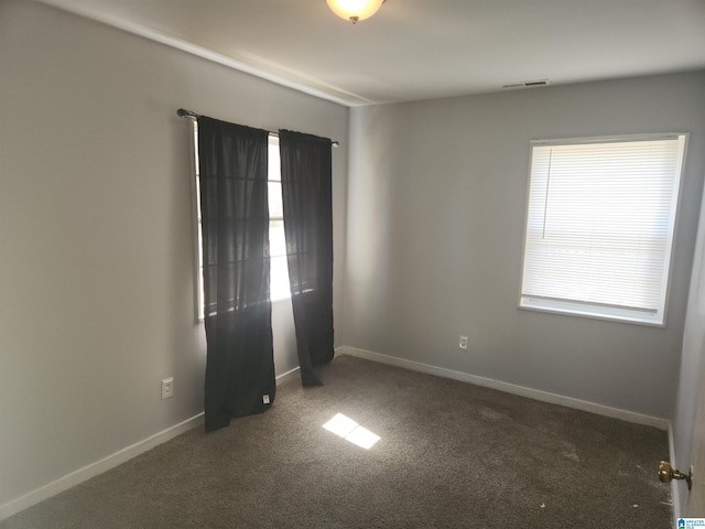 unfurnished room with carpet flooring, visible vents, and baseboards