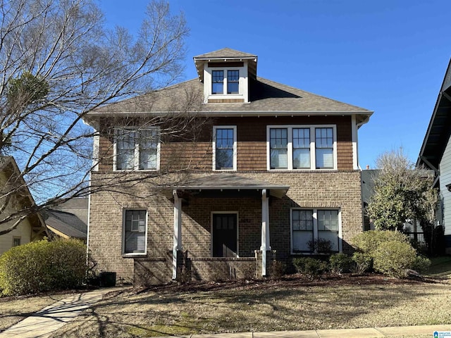 american foursquare style home featuring brick siding and a shingled roof