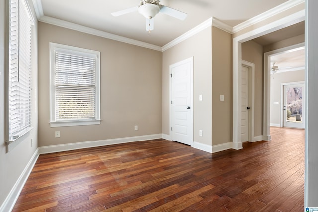 unfurnished bedroom featuring baseboards, dark wood-type flooring, ceiling fan, and crown molding