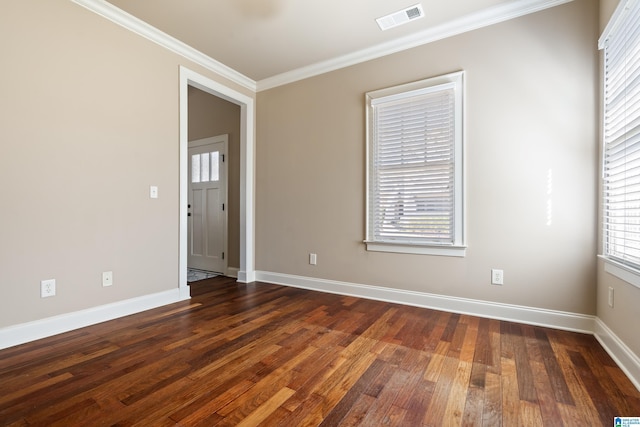 spare room with visible vents, baseboards, dark wood finished floors, and crown molding