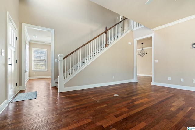 foyer featuring baseboards, an inviting chandelier, dark wood finished floors, and crown molding